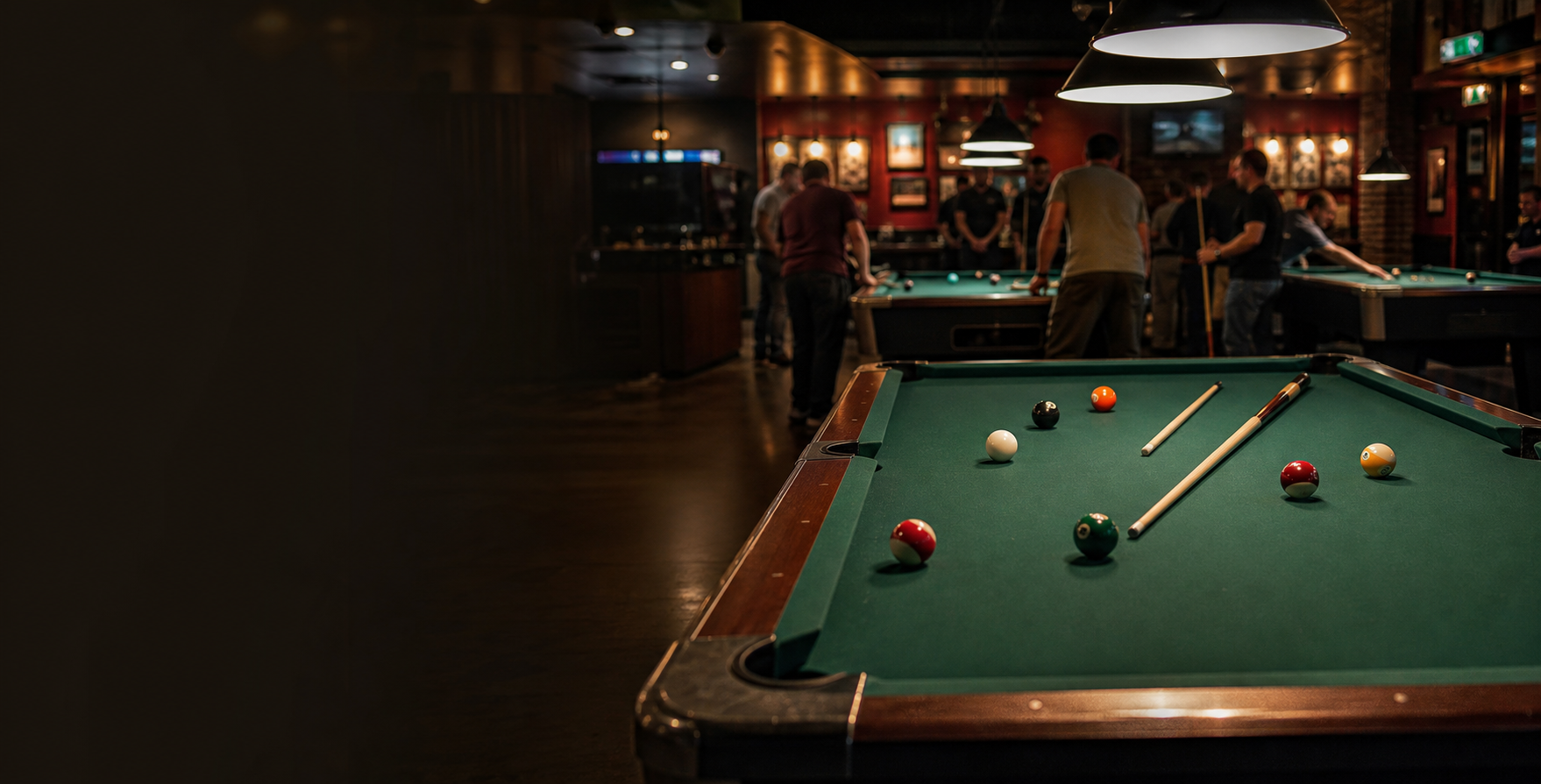 Pool tables under warm league-night lights